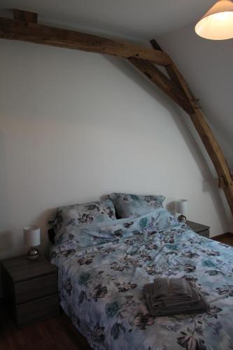 a bedroom with a bed with a blue comforter at Amazing renovated Loire Valley gite in La Pellerine