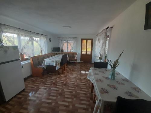 ein Wohnzimmer mit 2 Tischen und einem Kühlschrank in der Unterkunft Cabana Robert in Arieşeni