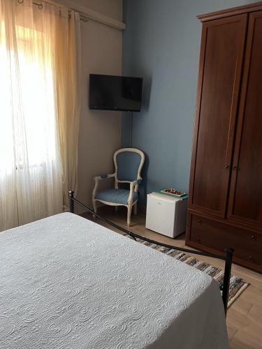 a bedroom with a bed and a chair and a tv at B&B Colle Cucchiara in Cassino