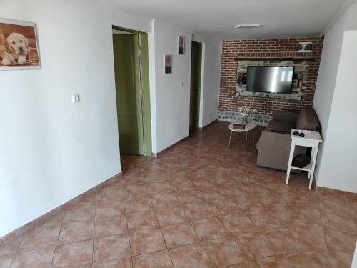 a living room with a couch and a tv at Bursa La in Kavala