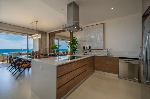 a kitchen and dining room with a view of the ocean at Luxury Condo with Ocean View, Balcony, and Pool in Cabo San Lucas