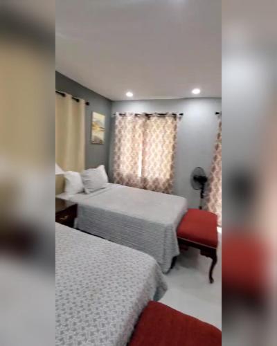 a hotel room with two beds and a red bench at Comfort Zone at The Ridge E17 in Ocho Rios