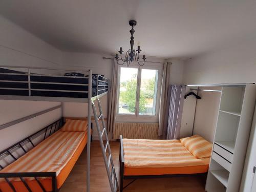 une chambre avec deux lits superposés et une fenêtre dans l'établissement Chambre familiale pour 2 adultes et 2 enfants, sdb et cuisine partagées, à Savigny-sur-Orge