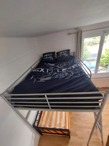 Ce lit superposé se trouve dans un dortoir doté d'une fenêtre. dans l'établissement Chambre familiale pour 2 adultes et 2 enfants, sdb et cuisine partagées, à Savigny-sur-Orge