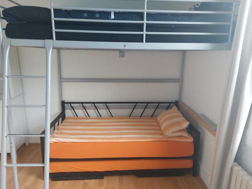 Cette chambre comprend un lit superposé avec un matelas orange. dans l'établissement Chambre familiale pour 2 adultes et 2 enfants, sdb et cuisine partagées, à Savigny-sur-Orge