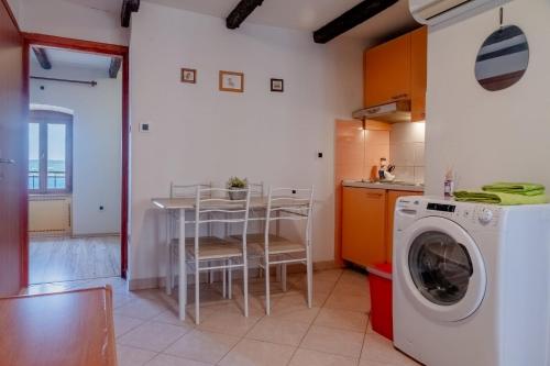 a kitchen with a washing machine and a table at Fiammetta in Rovinj