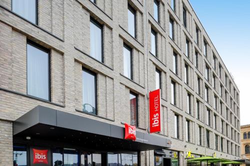 a large brick building with a red sign on it at Ibis Berlin Hauptbahnhof in Berlin