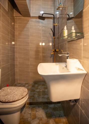 a bathroom with a sink and a toilet at Aseda by Judisol Apartments in Kwedonu