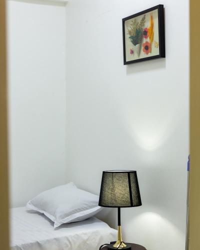 a lamp sitting on a table next to a bed at Aseda by Judisol Apartments in Kwedonu