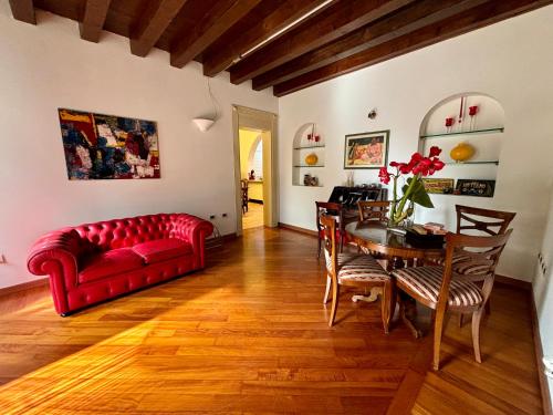 a living room with a red couch and a table at Casa Martita in Taglio di Po