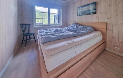 a small bedroom with a bed and a chair at Stunning Home In Hovden I Setesdal in Hovden