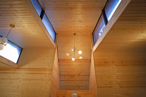 a room with wood paneling and skylights at Hotel Twins Surami in Surami