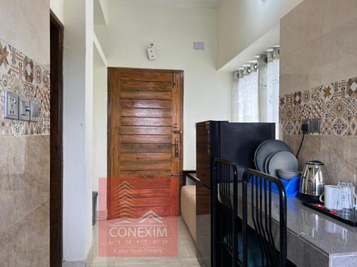 a kitchen with a refrigerator and a wooden door at Fully Furnished One Bed Room Apartment with Kitchen A007 in Dhaka