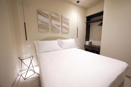 a bedroom with a large white bed and a table at Sebèl Camere di Charme in Barletta