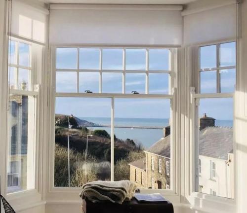 a room with a large window with a view of the ocean at A stunning 2 bed apartment in Fishguard
