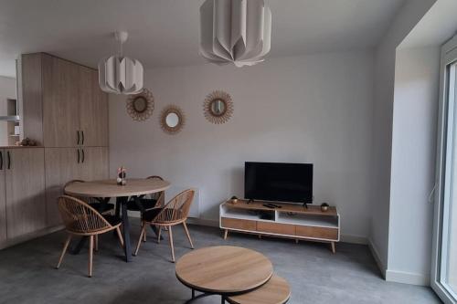 a living room with a table and chairs and a tv at Maison DEOLS centre 41 pour 1 ou 2 personnes in Déols
