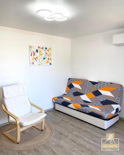 - une chambre avec un lit, une chaise et un tableau dans l'établissement LE SAOMA, studio cabine, parking privé, climatisation, à La Grande Motte
