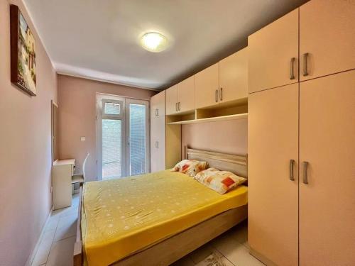 a small bedroom with a yellow bed and cabinets at Matija i Luka in Bijela