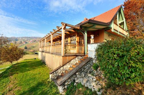 a wooden house with a deck on a hill at Villa Les with Hot tub & Sauna in Brežice