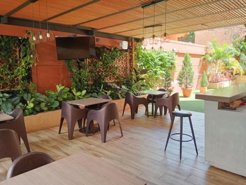 a restaurant with tables and chairs and a patio at Hotel Lomas 10 Medellin in Medellín