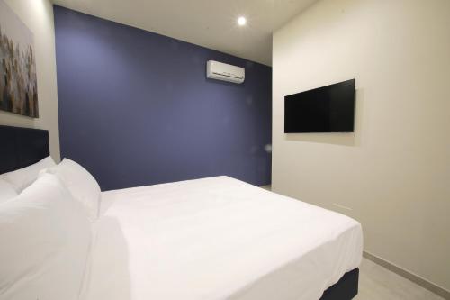 a bedroom with a white bed and a blue wall at Sebèl Camere di Charme in Barletta