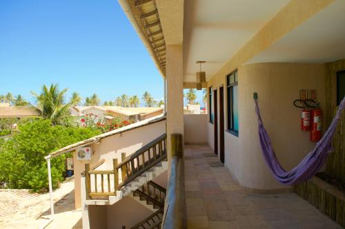 a balcony of a house with a hammock on it at Pousada Stella Tropical in Salvador