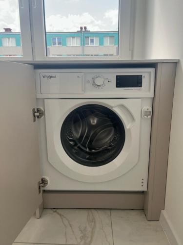 a washing machine in a room with a window at Sara Apartament in Turek
