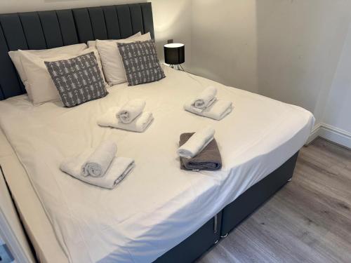 a bed with towels and slippers on it at Harrington Street Apartments Liverpool by Beehosting in Liverpool
