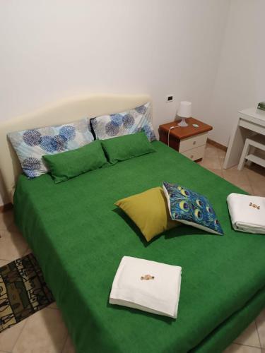 a green bed with a green sheets and pillows at La Casetta di Ugo in Grisignano di Zocco