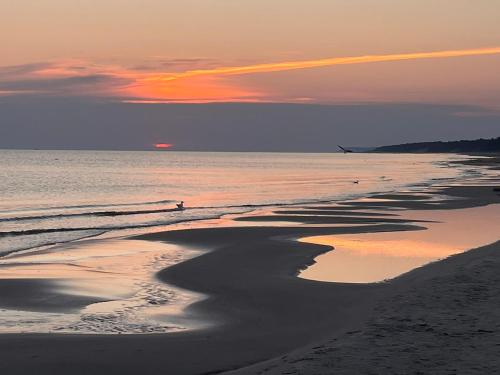 a sunset on the beach with the tide coming in at Lawendowe Zacisze 2 in Odargowo