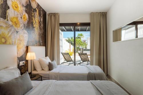 ein Hotelzimmer mit zwei Betten und einem Fenster in der Unterkunft Villa María in Playa Blanca