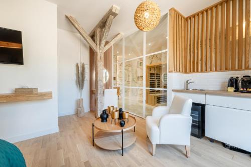 un salon avec un canapé, une table et une chaise dans l'établissement Studio Chic Sauna et bain Spa, à Vailly-sur-Aisne