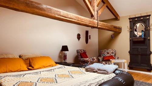 - une chambre avec un lit et deux chaises dans l'établissement Au bon endroit, à Sevremont