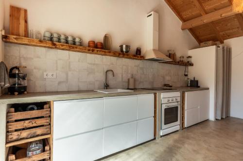 a kitchen with white cabinets and a white refrigerator at OAK Monte Alentejano - 2 casas T2 alugadas sempre em simultâneo toda a propriedade é exclusiva a uma só reserva in Santiago do Cacém