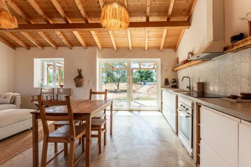 a kitchen and dining room with a wooden table and chairs at OAK Monte Alentejano - 2 casas T2 alugadas sempre em simultâneo toda a propriedade é exclusiva a uma só reserva in Santiago do Cacém