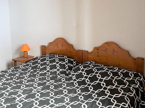- un lit avec une couette en noir et blanc dans l'établissement Appartement tout confort avec balcon, skis aux pieds, piscine chauffée, proche commerces et remontées mécaniques - FR-1-267-231, au Corbier