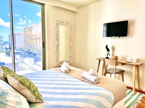Un dormitorio con una cama y una ventana grande. en Bayline luxury spa and pool apartment, en Armação de Pêra
