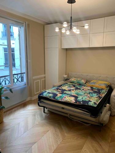 une chambre avec un lit dans une pièce avec une fenêtre dans l'établissement Super Apartment, comfort design functional, à Paris