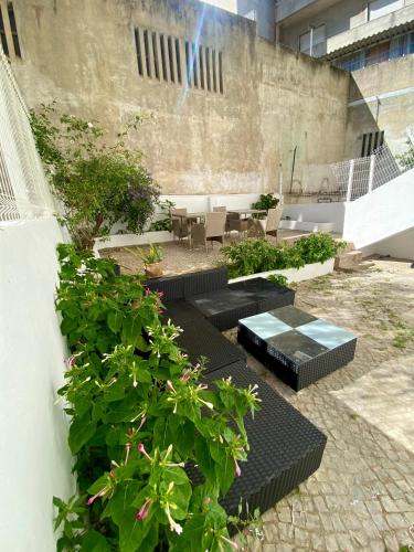 a courtyard with black benches and plants in a building at Refreshed apartment with private garden in Almada