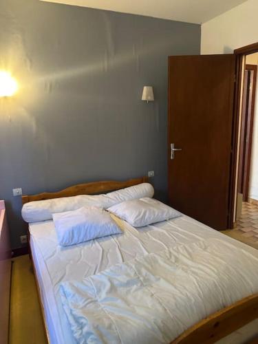 un lit avec deux oreillers dessus dans une chambre dans l'établissement Vaste villa au coeur de la pinède, aux Mathes