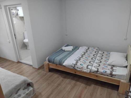 a small bedroom with a bed and a mirror at Tebdi Qor, Warm Home in Mestia