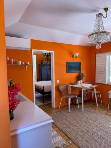 a living room with orange walls and a table at Jardim de Cascais in Cascais