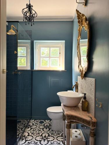 a bathroom with a sink and a toilet and a mirror at Jardim de Cascais in Cascais