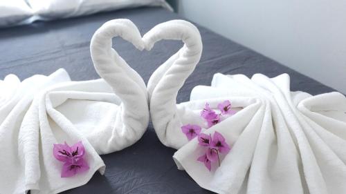 セリネにあるApartments Bonacaのベッドの上に花が飾られた白鳥の形をしたタオル2枚
