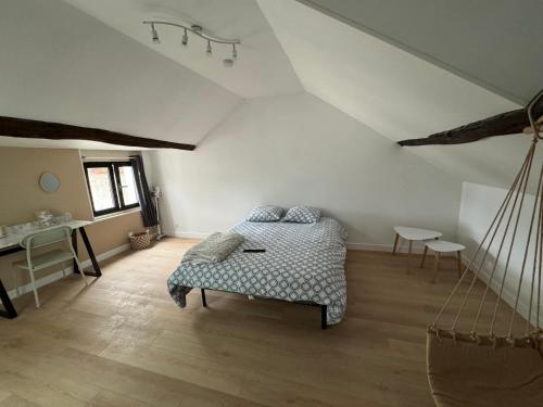 - une chambre mansardée avec un lit et un bureau dans l'établissement Le Rooftop - Terrasse vue Cathédrale - Netflix, à Orléans