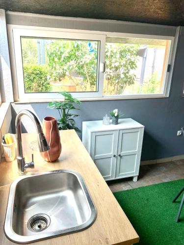 a kitchen with a sink and two windows at Apartman Lea in Vela Luka