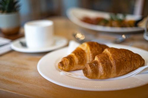 dos croissants en un plato blanco en una mesa en The Malvern Hills Hotel, en Great Malvern