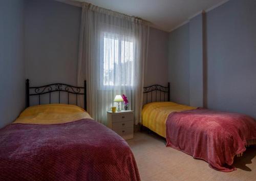 two beds in a room with a window at Casa Amy - Zona Naturista in Playas de Vera