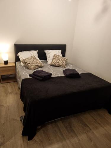- un lit noir avec des oreillers dans l'établissement Nid d'amour, à Bastia
