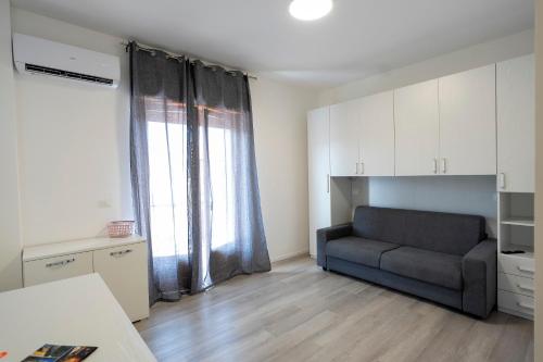 a living room with a couch in front of a window at Prestige House 6 in Scalea